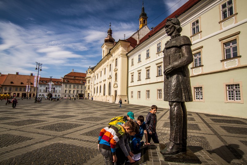 Elevi analizând statuia lui Gheorghe Lazăr din Piaţa Mare a Sibiului